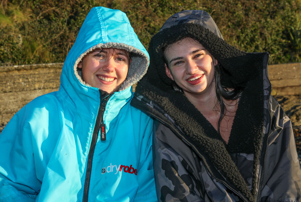 Caoimhe Nolan and Megan O'Byrne get warmed up after taking part in the UCC College Christmas Swim organised by the Students Union to raise funds for various charities at Fountainstown, Co. Cork. - Picture: David Creedon