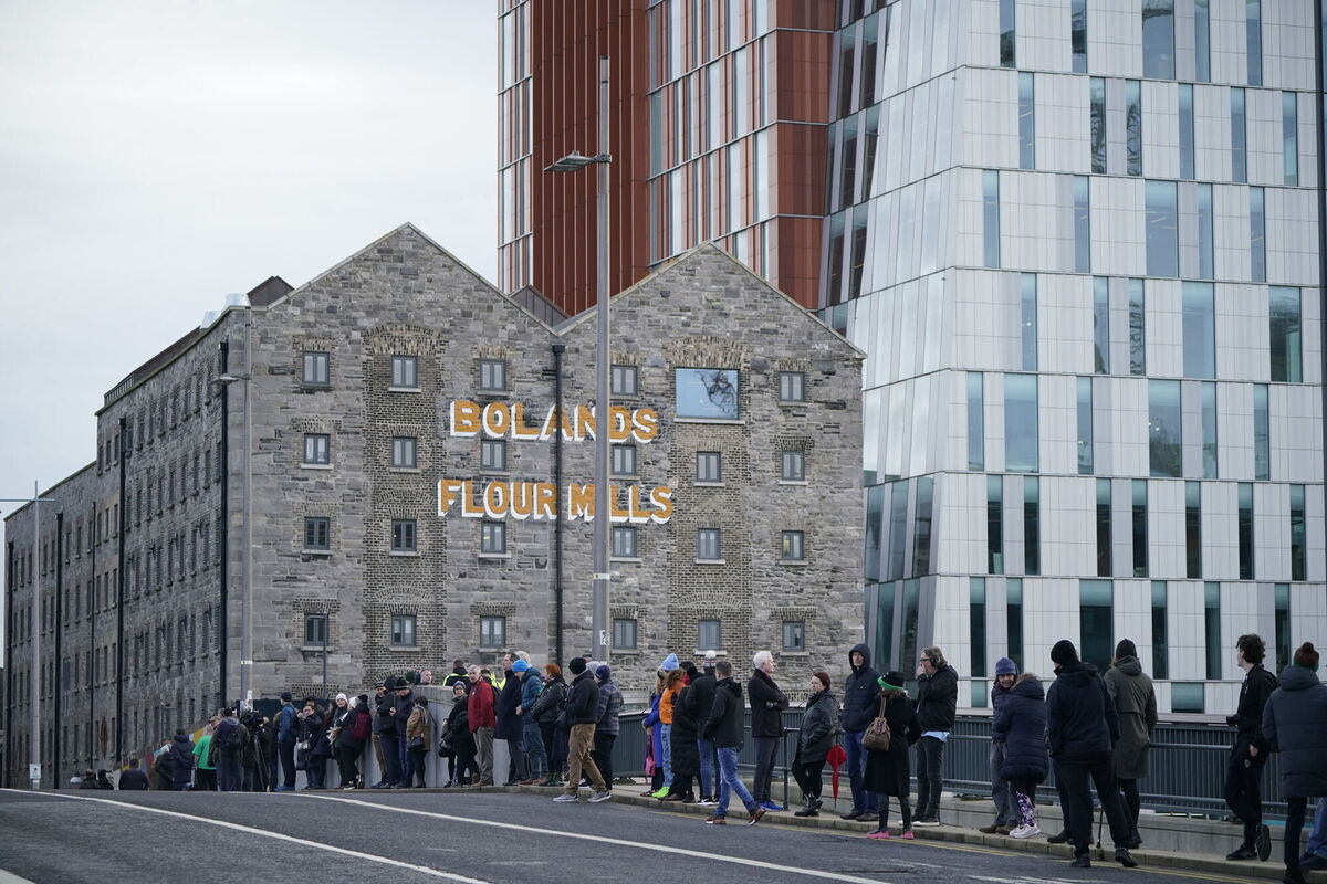 Crowds line the streets by Grand Canal dock as they wait for the funeral procession of Shane MacGowan to make its way through the streets of Dublin ahead of his funeral in Co Tipperary. Pic: Niall Carson/PA Wire Crowds line the streets by Grand Canal dock as they wait for the funeral procession of Shane MacGowan to make its way through the streets of Dublin ahead of his funeral in Co Tipperary. Pic: Niall Carson/PA Wire