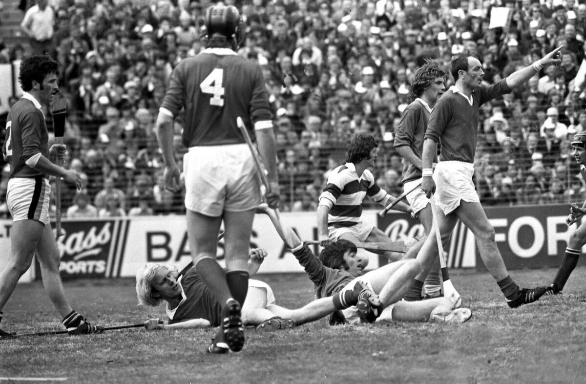 Cork defender Denis Coughlan tries to attract the referee's attention as Cork defender John Horgan and Limerick forward Joe McKenna end up on the ground after a scramble for possession in 1976. Cork defender Denis Coughlan tries to attract the referee's attention as Cork defender John Horgan and Limerick forward Joe McKenna end up on the ground after a scramble for possession in 1976.