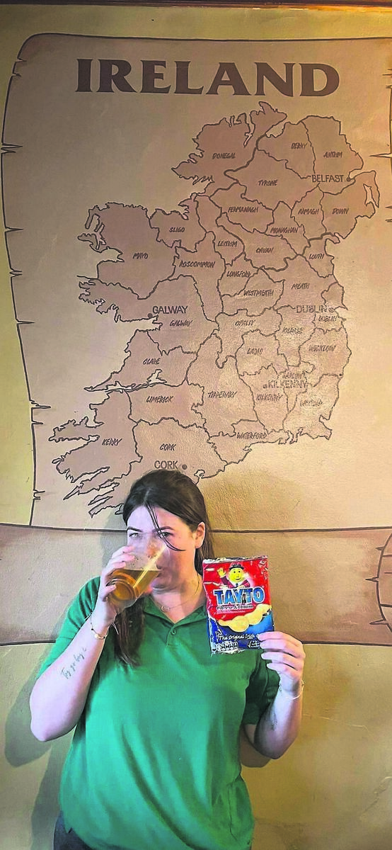 A TASTE OF HOME: Emily Maher in her local Irish bar, Póg Mo Thones, in Queenstown, with her beloved Taytos and a pint A TASTE OF HOME: Emily Maher in her local Irish bar, Póg Mo Thones, in Queenstown, with her beloved Taytos and a pint
