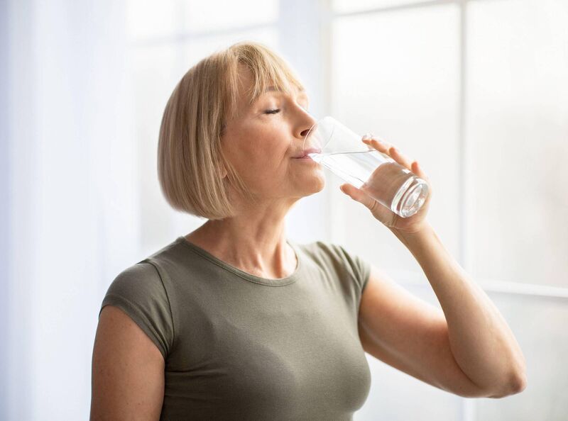 A Generic Photo of woman drinking water from a glass. 