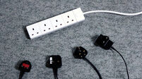 Unused extension lead and four disconnected plugs lying on carpet
