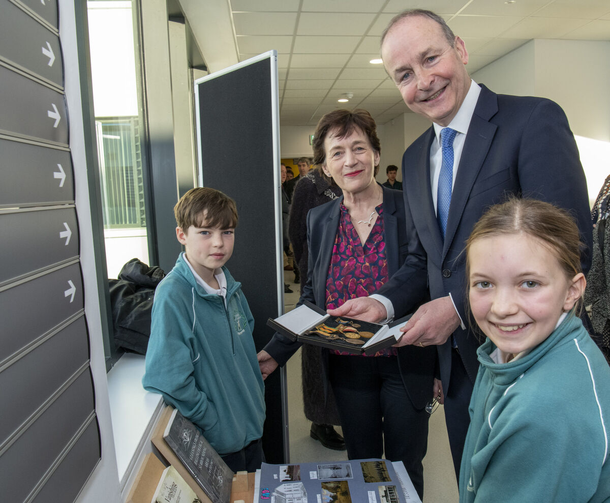 An Tánaiste Micheál Martin, meeting pupils Matthew Finn and Emm Ní hAlpín and school principal Máire Uí Shé from Gaelscoil an Chaisleáin. Matthew showing his greatgrandfather's medals from the War of Independence. Pic: Brian Lougheed