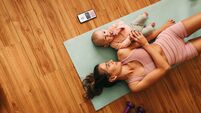High angle view of a mom lying on an exercise mat with her baby
