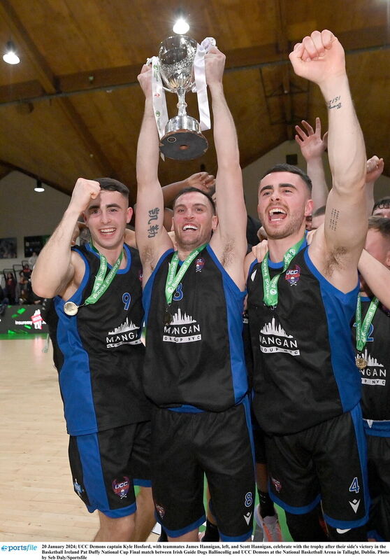 UCC Demons captain Kyle Hosford, with teammates James and Scott Hannigan, celebrate with the National Cup. Picture: Seb Daly/Sportsfile