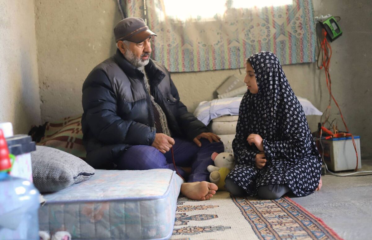 Rafiq and his daughter, Leila, collecting household items from their damaged apartment. Rafiq and his daughter, Leila, collecting household items from their damaged apartment.