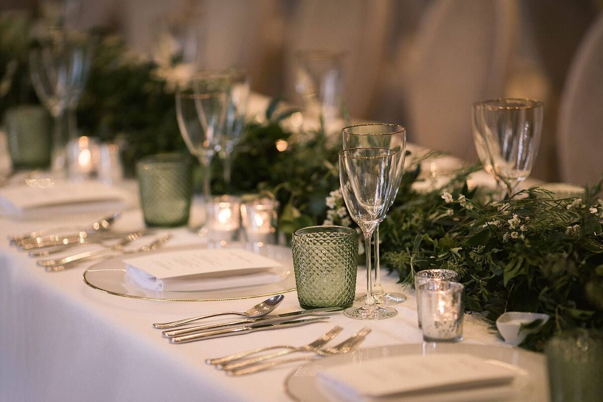 A wedding table setting with foliage and candles. 