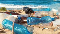 Spilled garbage on the beach of the big city. Empty used dirty plastic bottles. Empty used dirty plastic bottles. Dirty sea sand