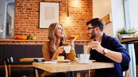 Couple of young people drinking coffee and eating cake in a stylish modern cafeteria
