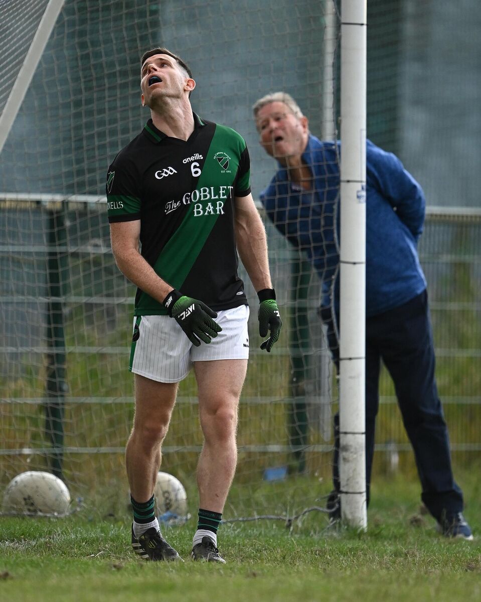 Stephen Cluxton of Parnells looks on, alongside umpire Martin Flanagan, as a ball sails over the over. Picture: Piaras Ó Mídheach/Sportsfile