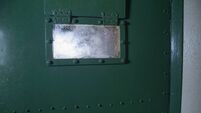 Window on a green prison door