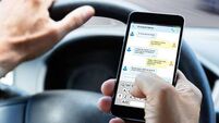 Man Typing Text Message On Mobile Phone While Driving Car