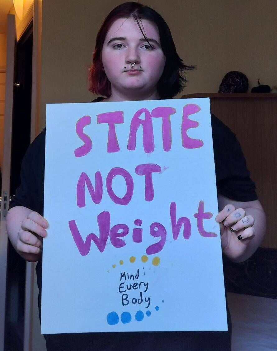 Pictured is Luna Fleming with an eating disorder reform campaign poster. Pictured is Luna Fleming with an eating disorder reform campaign poster.