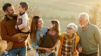 Happy multi-generation family talking while taking a walk on a hill.