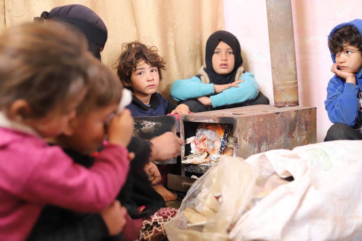 The younger members of Hamoud’s family are trying to keep warm by burning plastic, often the only heating fuel available to them. Idleb, Syria. February 2024. The younger members of Hamoud’s family are trying to keep warm by burning plastic, often the only heating fuel available to them. Idleb, Syria. February 2024.