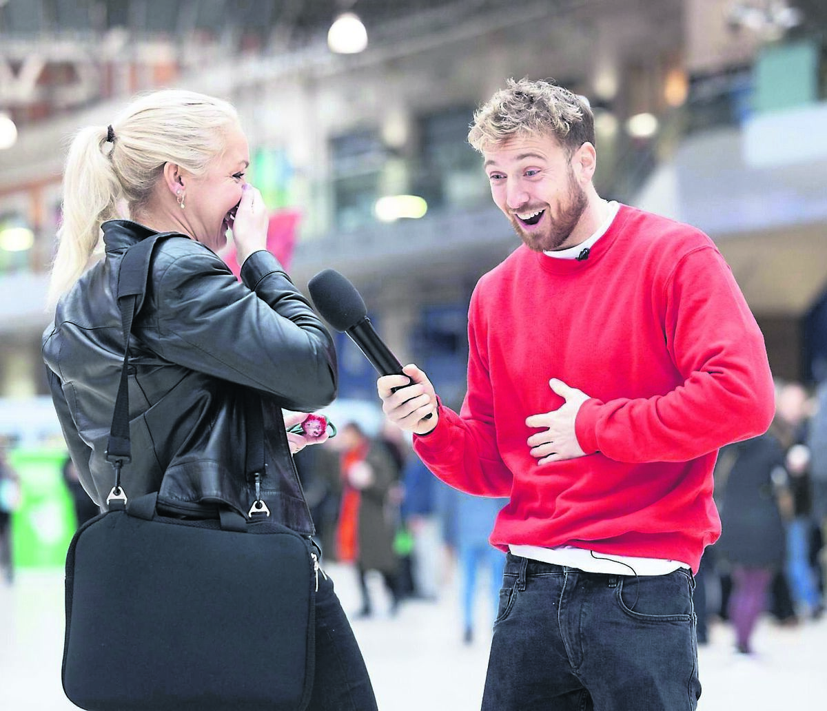TV and radio personality Sam Thompson laughing with a woman at Waterloo Station in London TV and radio personality Sam Thompson laughing with a woman at Waterloo Station in London