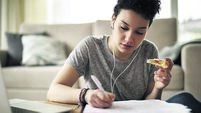 Female student studying and listening to music at home