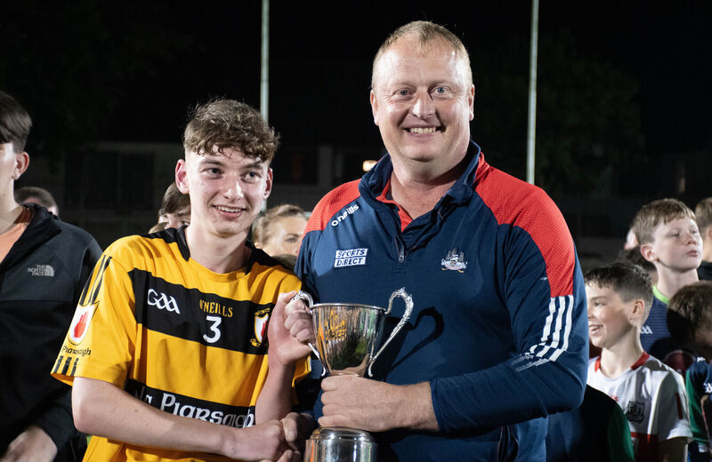 Peter Watson presents Na Piarsaigh captain Darragh O'Leary with the Rebel Óg U15 Premier trophy following the victory over Ballincollig. Picture: Howard Crowdy