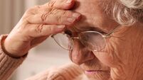 Senior woman with headache at home, closeup. Symptom of age-related memory impairment