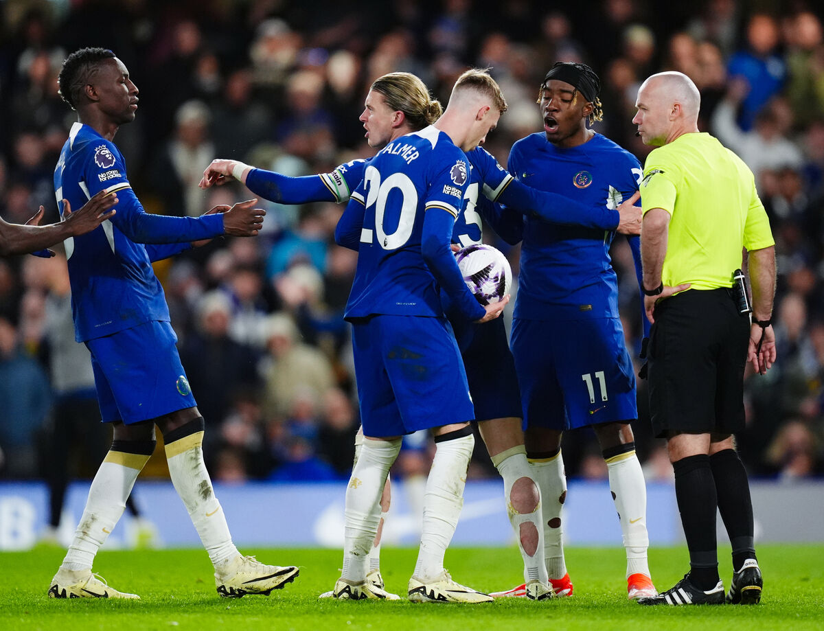 Chelsea's Cole Palmer holds onto the ball as Chelsea player discuss who will take the penalty during the Premier League match at Stamford Bridge, London.