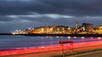 An illuminated city at night at the bank of an ocean bay
