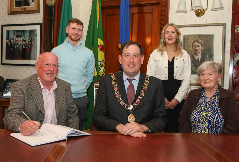 Photographer Eddie O'Hare signing the visitors book at a reception hosted by the Lord Mayor of Cork, Cllr. Kieran McCarthy at the City Hall, Cork to honour their contribution to the city for the past 45 years. Picture shows Eddie O'Hare, Alan O'Hare, Lord Mayor of Cork Cllr. Kieran McCarthy and Emma and Muriel O'Hare. - Picture: David Creedon