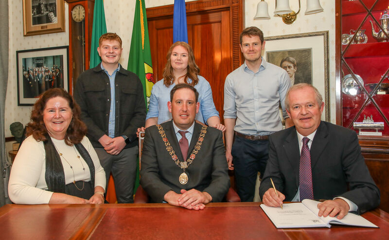 Photographer Denis Minihane signing the visitors book at a reception hosted by the Lord Mayor of Cork, Cllr. Kieran McCarthy at the City Hall, Cork to honour his contribution to the city for the past 45 years. Picture shows, Meave Minihane, Laura Minihane, Shane Minihane, Lord Mayor of Cork Cllr. Kieran McCarthy and David and Denis Minihane. Picture: David Creedon