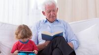 A grandfather and grandchild reading a book