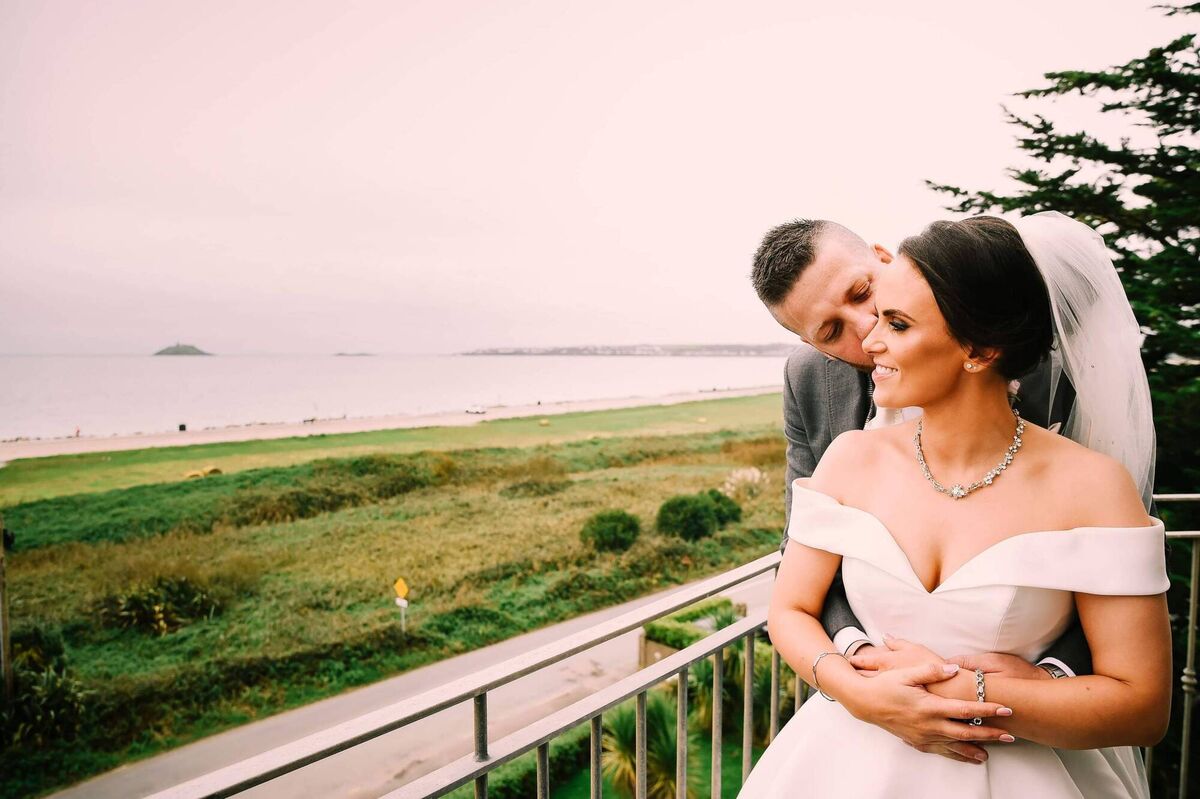 The couple in their happy place, Garryvoe beach. The bride did all the invites, candles and mass booklets herself and flowers were by June Blooms.