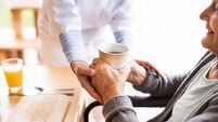 Unrecognizable health visitor and a senior woman during home visit.