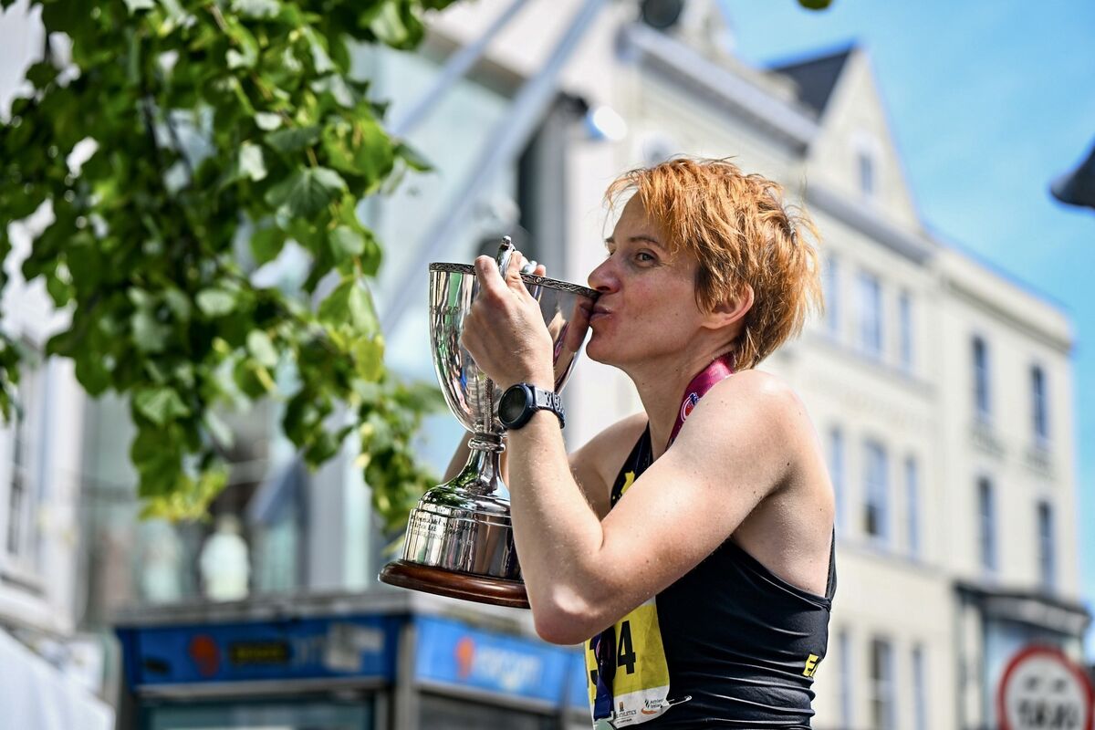 Aoife Cooke, winner of the women’s category in the 2024 Cork City Marathon kisses the trophy in delight. Picture: Chani Anderson