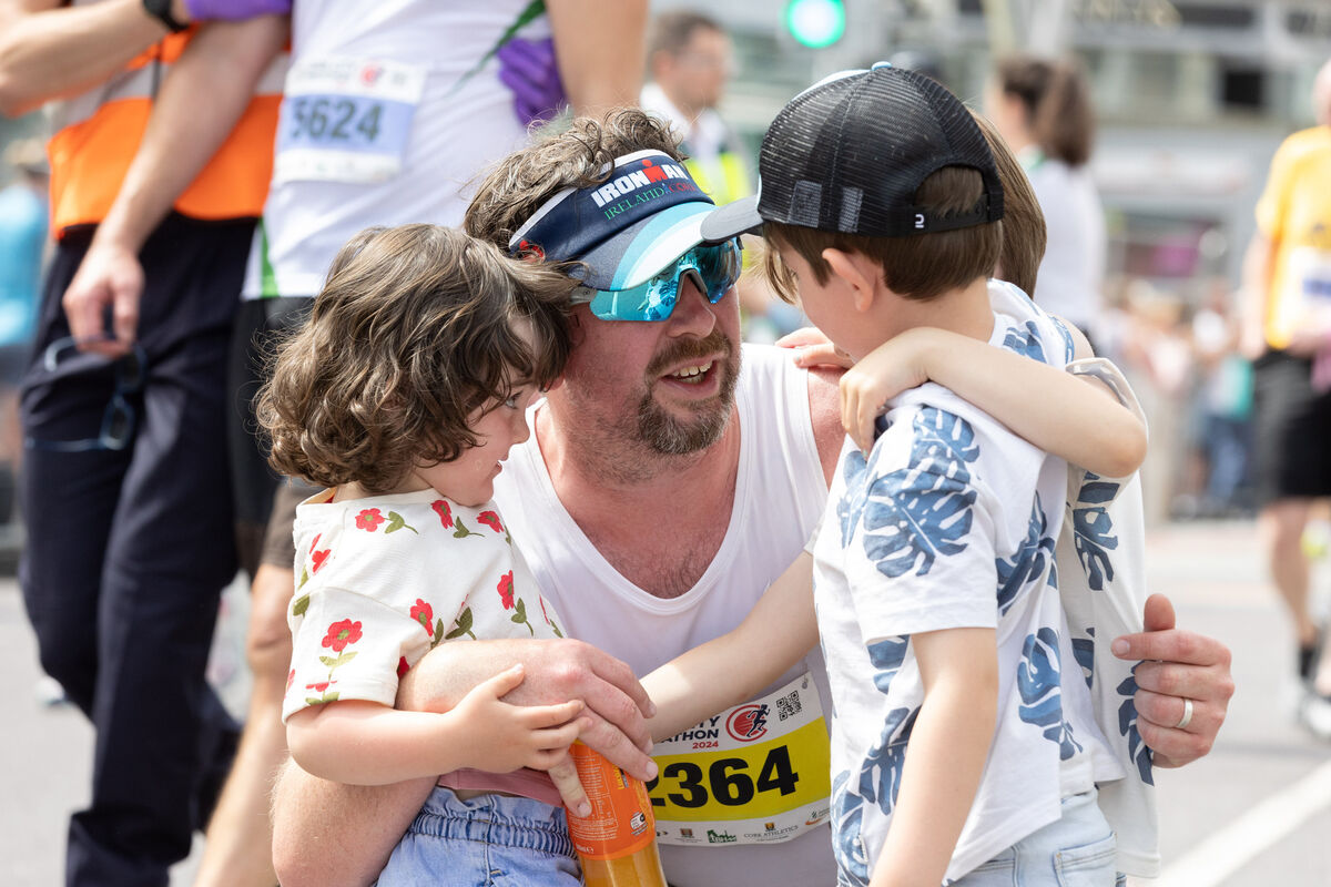 Gerard Maher embracing his children Milly, Alfie and Finn Maher from Oysterhaven at the finish line of the Cork City Marathon.