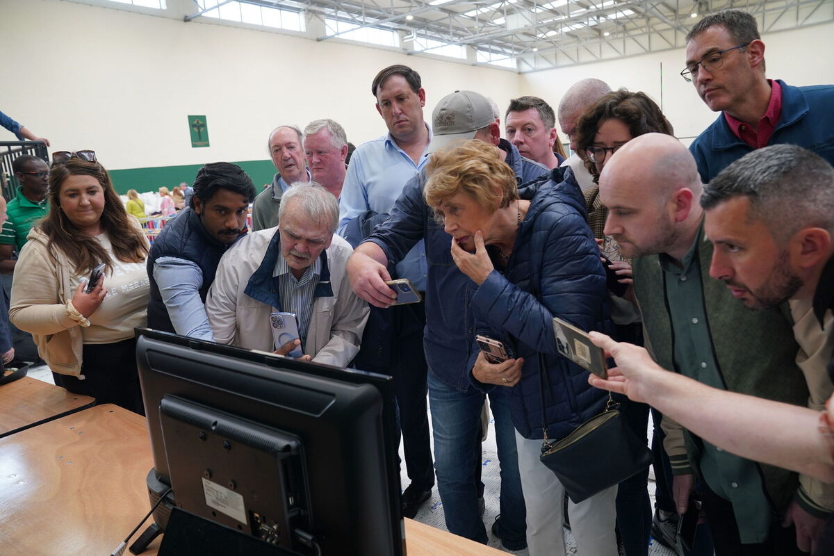 People looking at a television which of showing the tally of ballots at Nemo Rangers GAA club during counting for local and European elections in Cork. Photo credit: Jonathan Brady/PA Wire