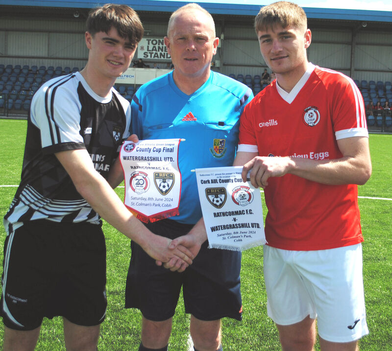 Rathcormac's captain Richard Morrisson (left) exchanges pennants with Watergrasshill's Sean Desmond, watched by referee Mark O'Connell.