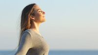 Woman breaths fresh air on the beach