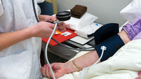 A nurse is measuring the blood pressure from a patient in a hospital