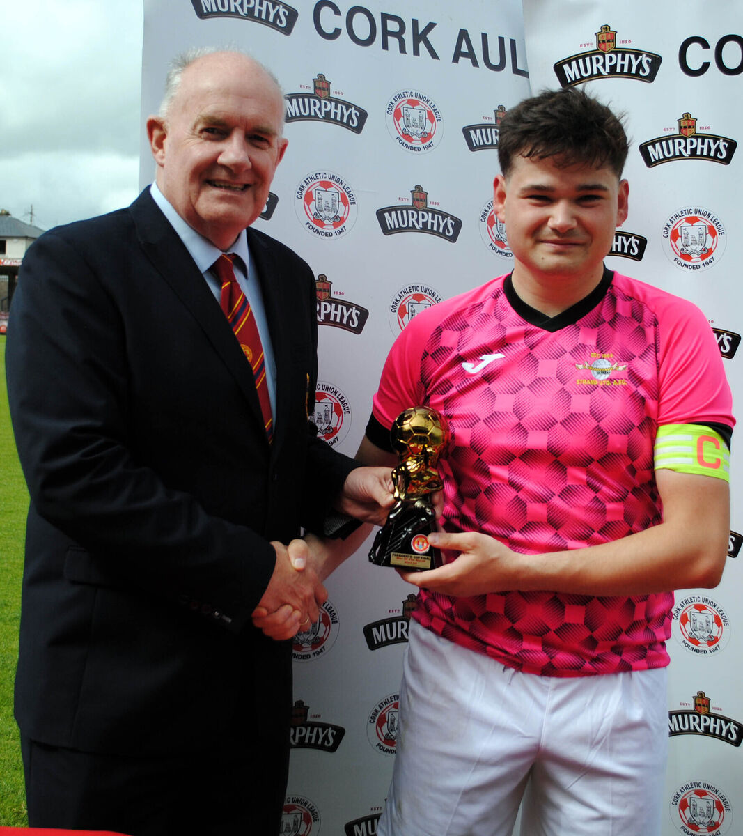 Dan Flynn (Cork AUL) presents the man of the match trophy (sponsored by Gary McCarthy Trophies) to Strand United B's Dave Og Coleman. Dan Flynn (Cork AUL) presents the man of the match trophy (sponsored by Gary McCarthy Trophies) to Strand United B's Dave Og Coleman.