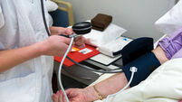 A nurse is measuring the blood pressure from a patient in a hospital