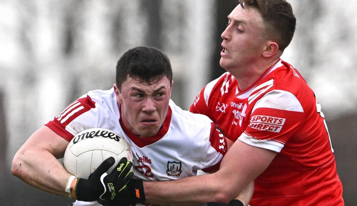 Mark Cronin of Cork is tackled by Ryan Burns of Louth. Picture: Ben McShane/Sportsfile