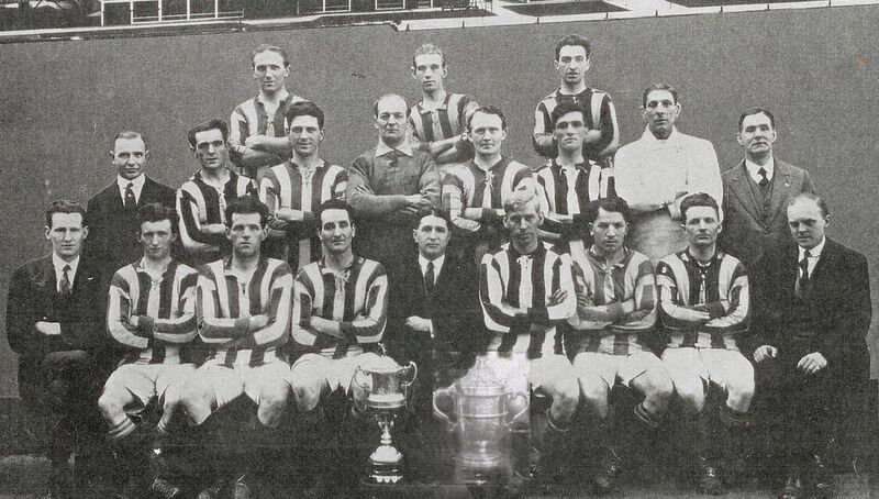 Fordsons, FAI Free State Cup winners in 1926, with the trophy. Back: Paddy Kelly, Mal McKinny, Dinny Driscoll. Middle: L R Dalton (finance), Sally Connolly, Barney Collins, Bill O’Hagan, Jack Carabine, Jack Baylor, Jack Finn (trainer), J Leddy (comm). Front: Percy Rocky (treas), Billy Hannon, Jack Sullivan (capt), Frank Brady, H Scott (Manager Henry Fords), Harry Buckle, Dave Roberts, Paddy Barry, P J Gilhooley (sec). Fordsons, FAI Free State Cup winners in 1926, with the trophy. Back: Paddy Kelly, Mal McKinny, Dinny Driscoll. Middle: L R Dalton (finance), Sally Connolly, Barney Collins, Bill O’Hagan, Jack Carabine, Jack Baylor, Jack Finn (trainer), J Leddy (comm). Front: Percy Rocky (treas), Billy Hannon, Jack Sullivan (capt), Frank Brady, H Scott (Manager Henry Fords), Harry Buckle, Dave Roberts, Paddy Barry, P J Gilhooley (sec).