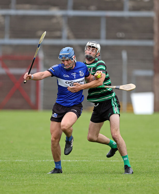  Paul Leopold of Sarsfields holds possession despite the attentions of Douglas's Mark Howll. Picture: Jim Coughlan