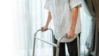 Close up hand of Asian Senior elderly disabled man patient walk slowly with walker at nursing home. Older handicapped male have