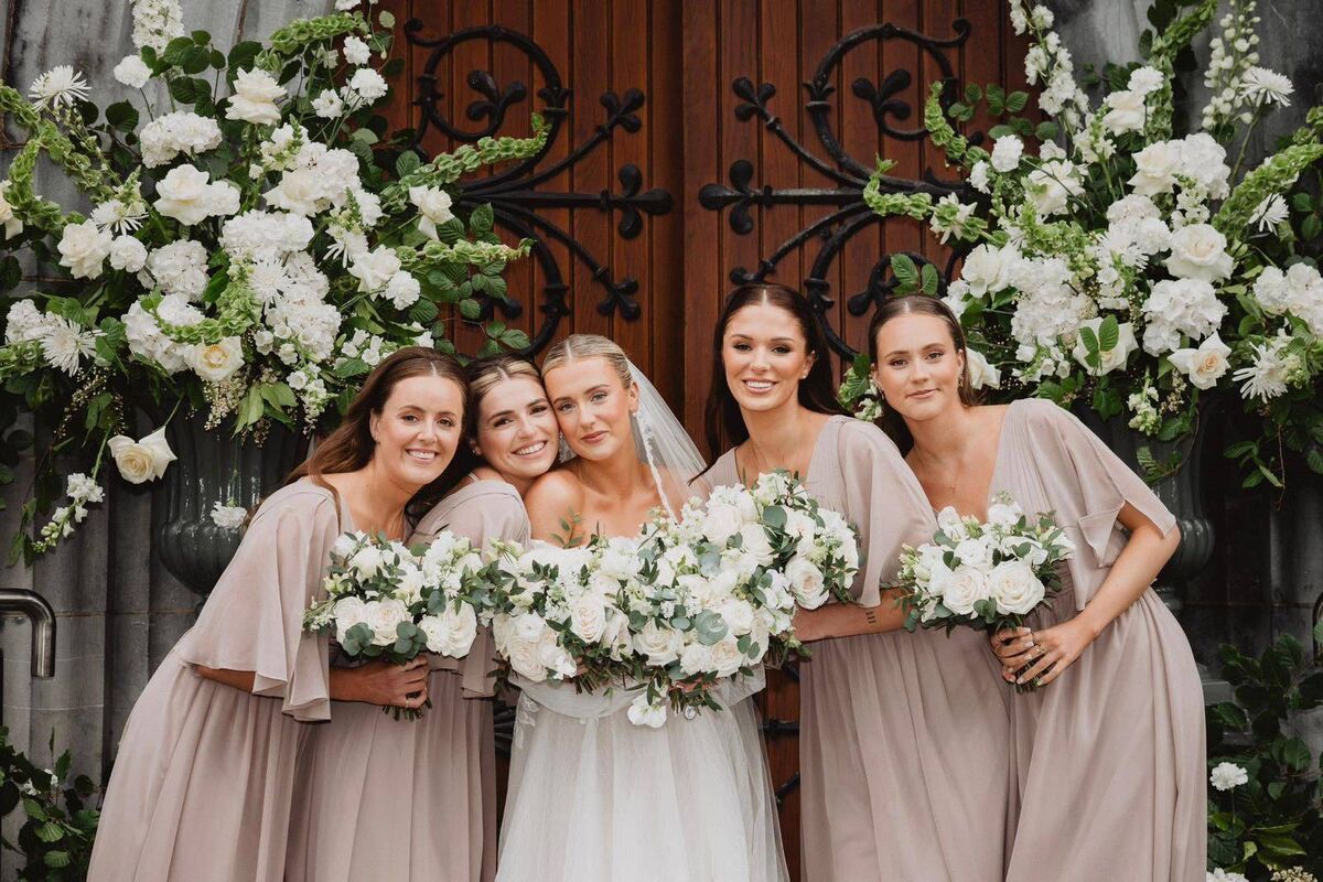 Bride Leah Comiskey with her wedding party on her wedding day. The flowers were by Tie The Knot Weddings Luxury Wedding Flowers.