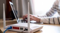 Selective focus at router. Internet router on working table with blurred man connect the cable at the background. Fast and high