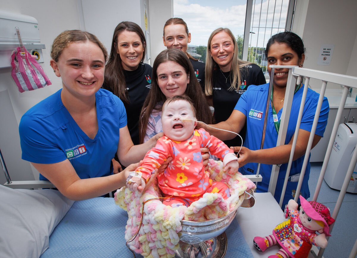 Lily Maher pictured in the O’Duffy Cup with her mother Courtney McMenamy (centre) and nurse Abi Farmer, Cork’s Molly Lynch, Meabh Cahalane, Izzy O’Regan and nurse Resmi Kollamyalil Lily Maher pictured in the O’Duffy Cup with her mother Courtney McMenamy (centre) and nurse Abi Farmer, Cork’s Molly Lynch, Meabh Cahalane, Izzy O’Regan and nurse Resmi Kollamyalil