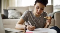 Female student studying and listening to music at home
