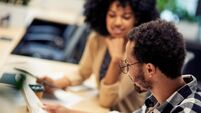 Two young diverse colleagues working together in the office. Business and teamwork concept