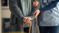 Nurse assisting senior with walking cane