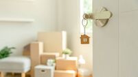 Moving house, relocation. The key was inserted into the door of the new house, inside the room was a cardboard box containing pe