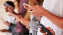 Teenage Students Using Digital Devices On College Campus